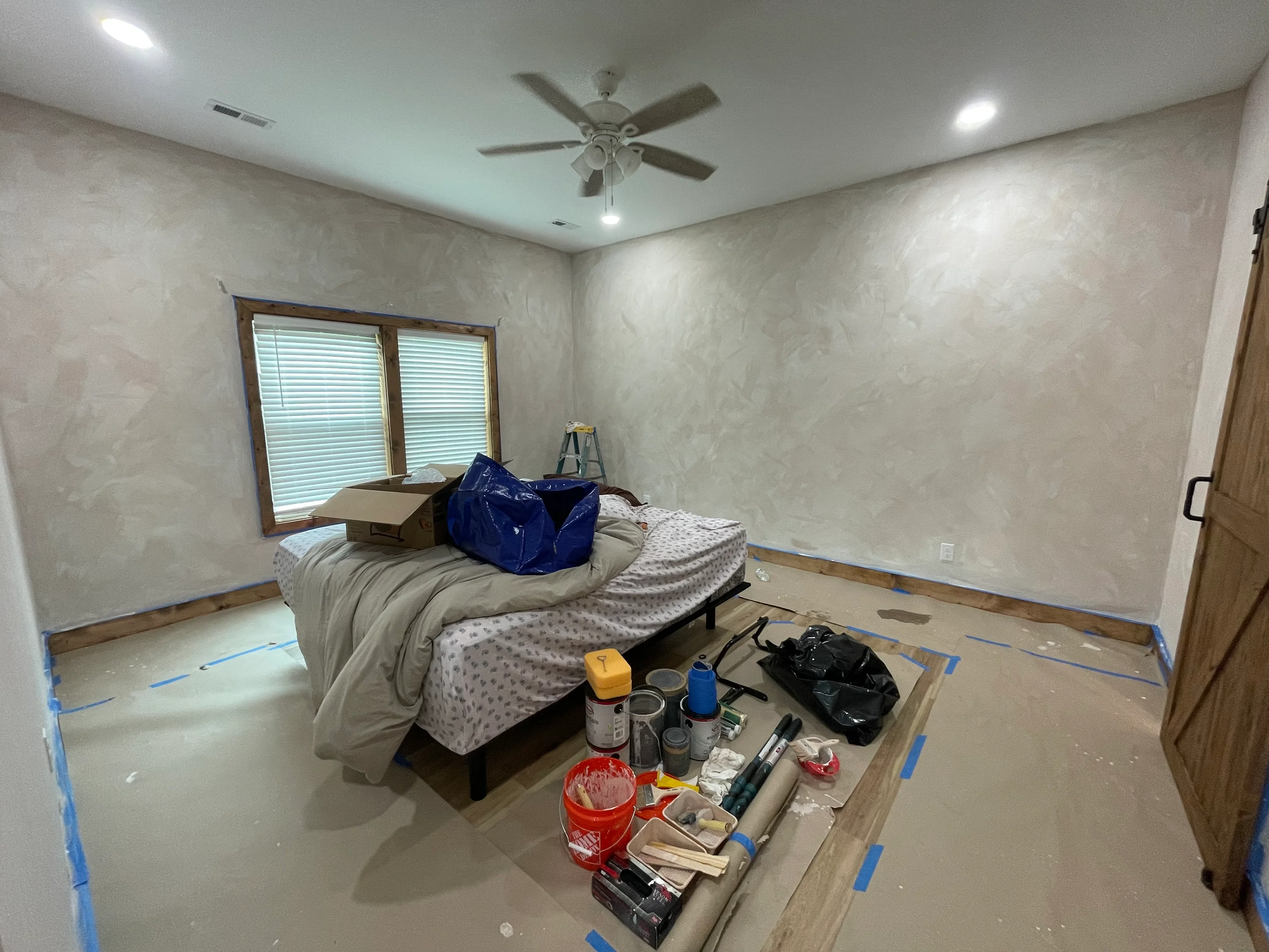 Light gray epoxy floor with wood-grain baseboards, recessed lighting, and ceiling fan in bedroom